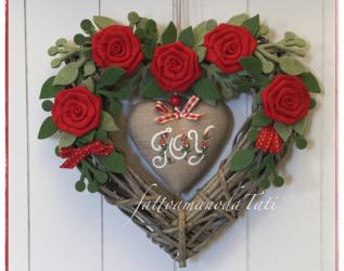 Cuore di vimini decorato con rose rosse e cuore di lino con la scritta joy
