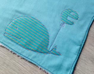 Asciugamano personalizzato per il fasciatoio con il monogramma del bambino appeso ad una dolce e morbida balena