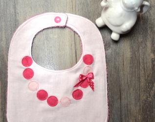 Bavaglino con finta collana e fiocco