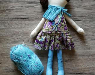Bambola di stoffa Amicoccola con vestito in fantasia floreale viola e accessori in lana azzurri con sfumature viola