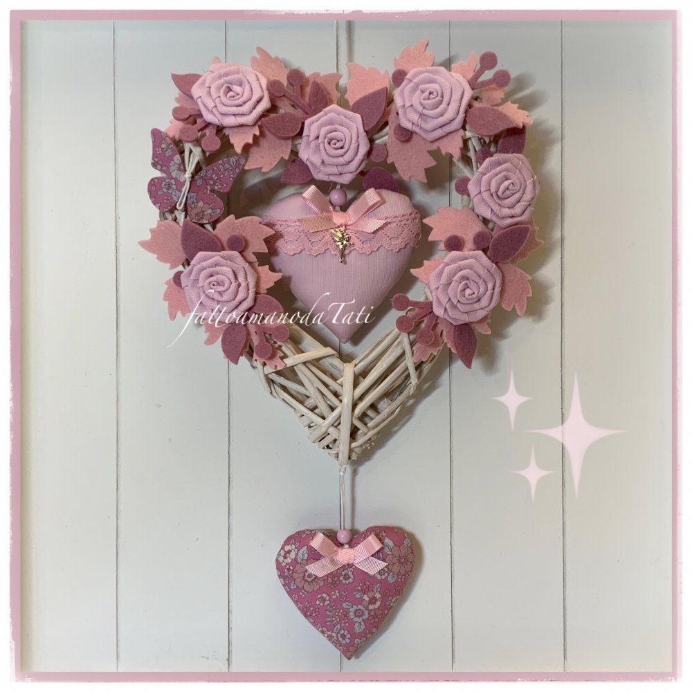 Cuore nascita in viticcio decorato con rametti, roselline, farfalla e due cuori sui toni del rosa e malva 