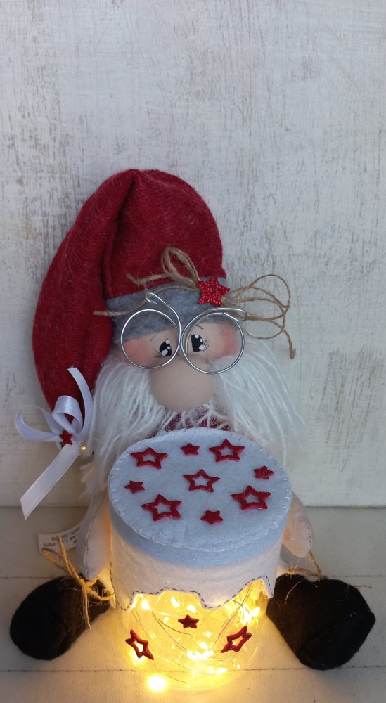 babbo natale seduto con barattolo stellato illuminato