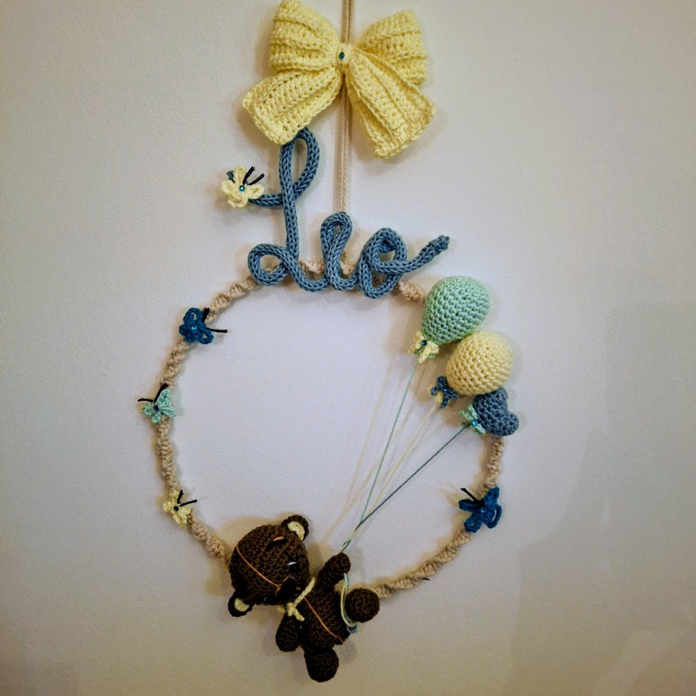 Fiocco nascita artigianale con nome in tecnica tricotin, cerchio in metallo rivestito con lavorazione artigianale in macram� con orsetto, palloncini  e fiocco amigurumi. Farfalline ad uncinetto.