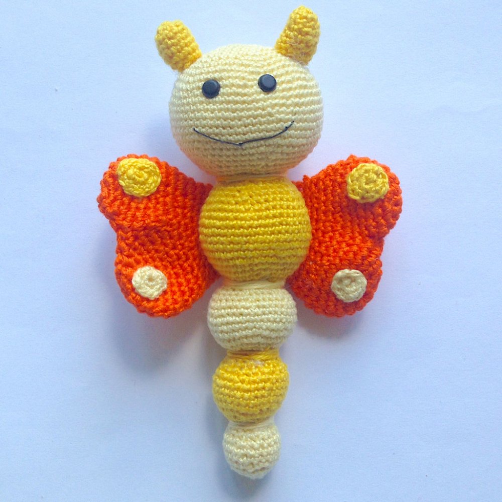 Sonaglino farfalla amigurumi arancione e gialla, morbida e tenera, fatta a mano all'uncinetto