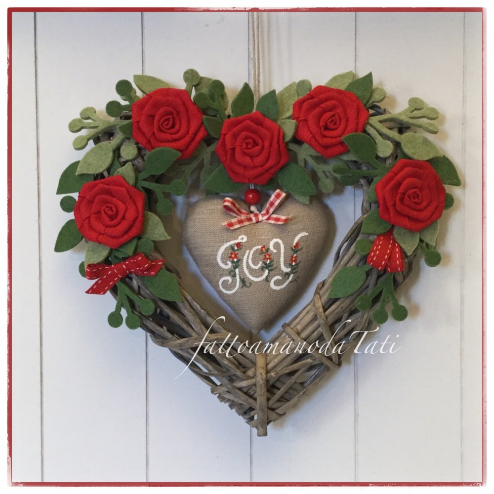 Cuore di vimini decorato con rose rosse e cuore di lino con la scritta joy