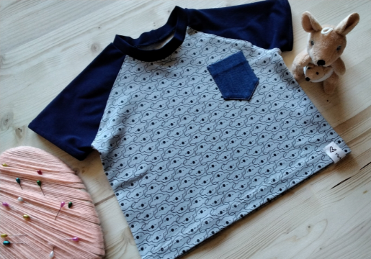 T-SHIRT in jersey di cotone con stampa koala su base grigio chiaro, manica raglan di secondo colore blu. Handmade